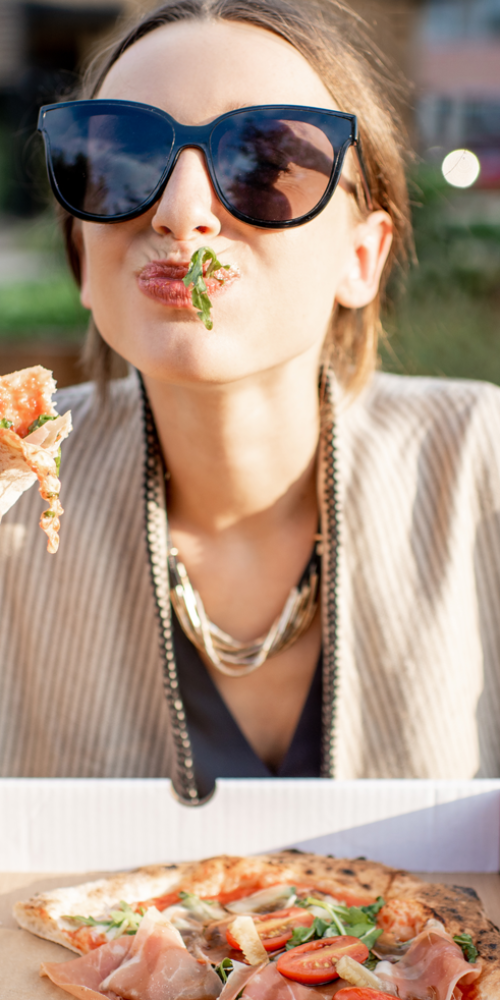 woman-eating-pizza-outdoors-2021-12-09-04-30-58-utc